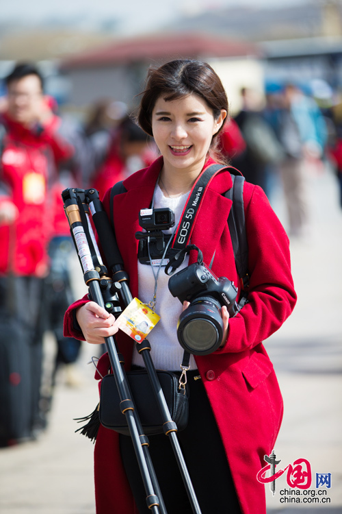 2016年兩會，人民大會大堂前，一位笑容燦爛的紅衣女記者正步入大會堂。中國網(wǎng) 鄭亮 攝